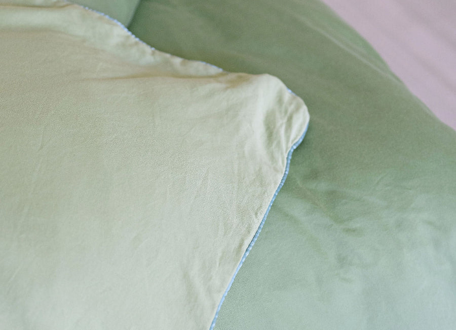 Close-up of light green bedding with a soft texture